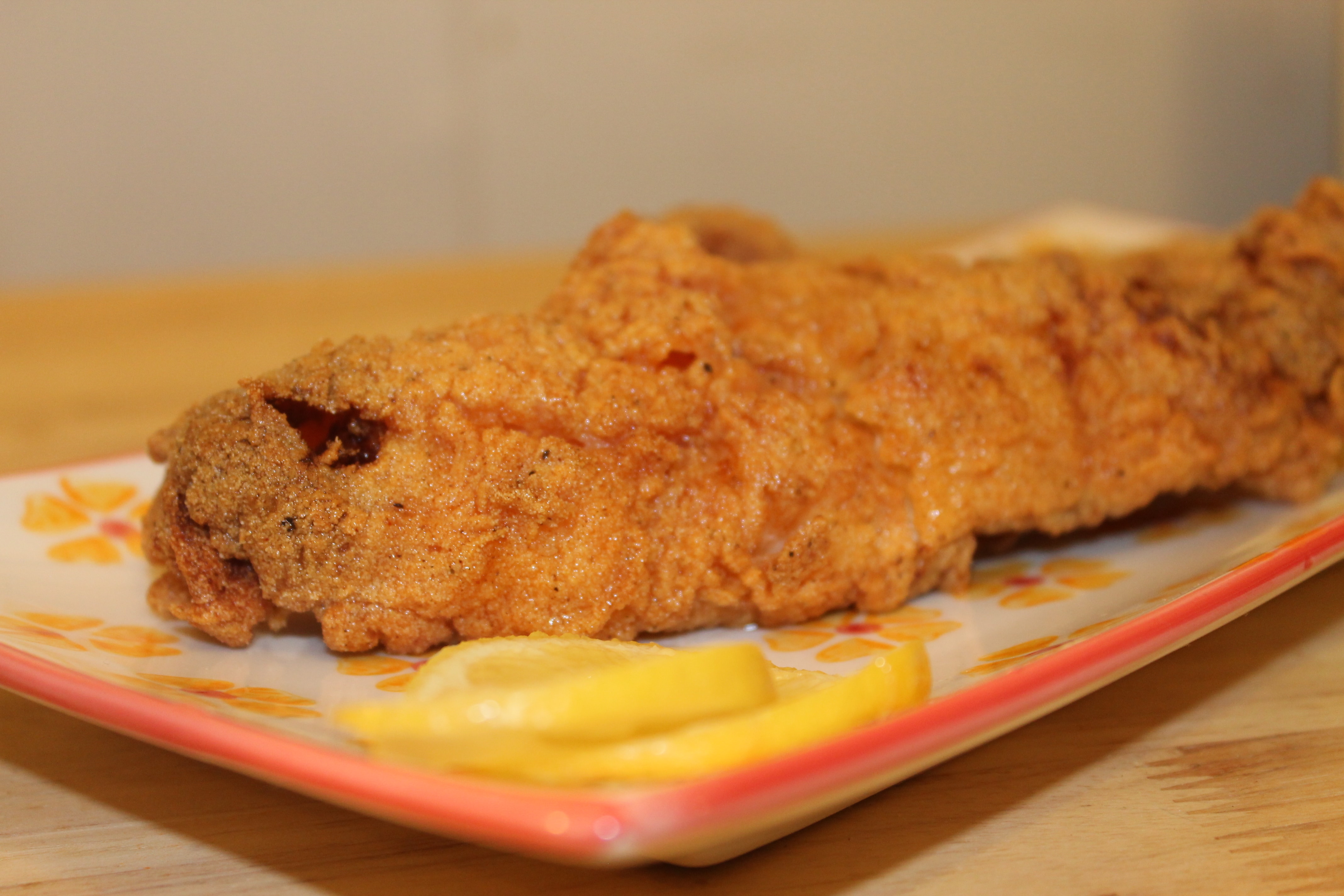 Fried Catfish on a plate with lemon slices