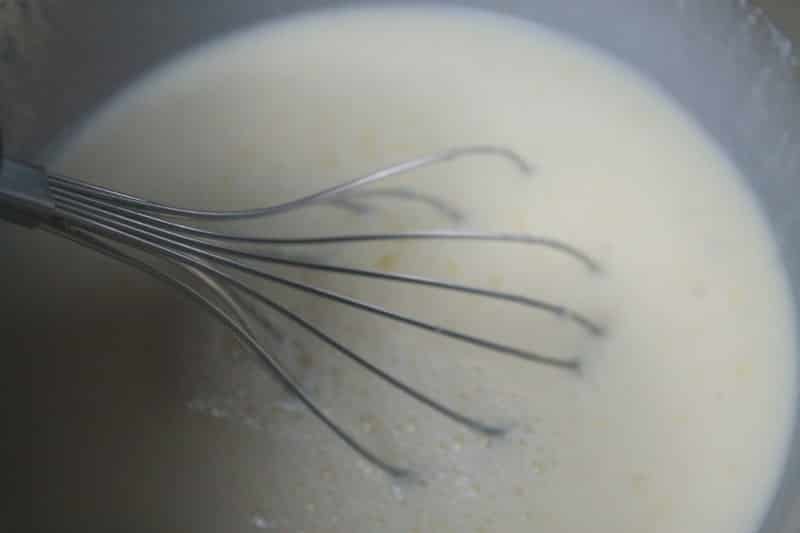 milk and eggs with a whisk in it