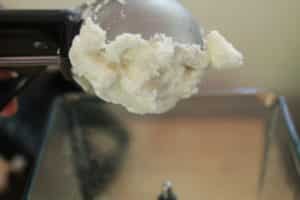 Vanilla Ice Cream on ice cream scoop getting placed in blender
