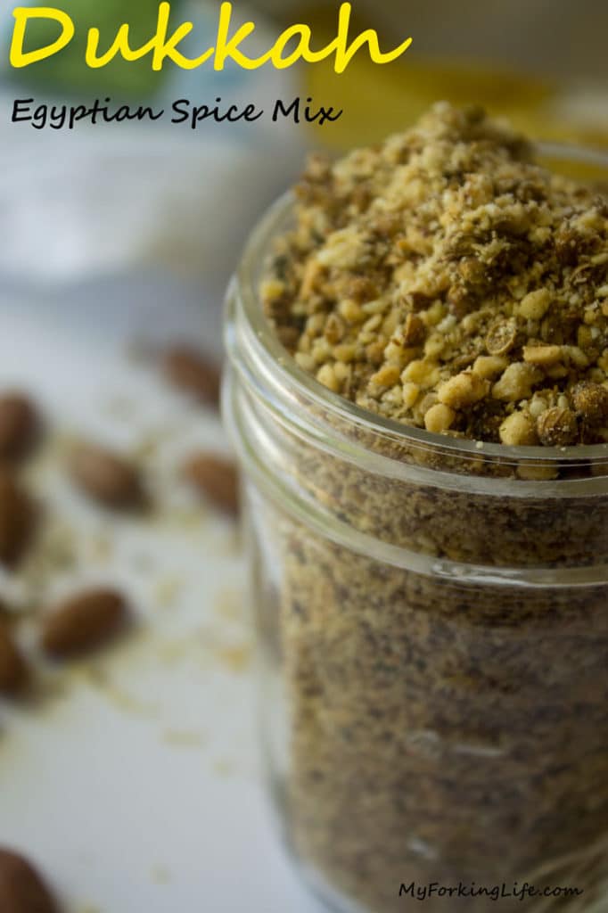 pin image of dukkah seasoning in glass jar. 