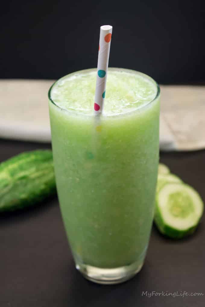 Cucumber ginger juice in glass with paper straw