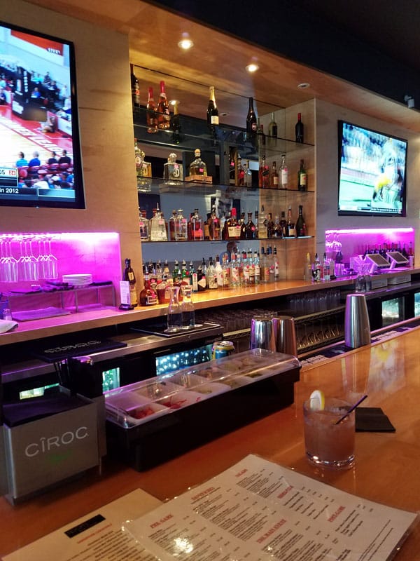 photo of bar with tvs and alcohol