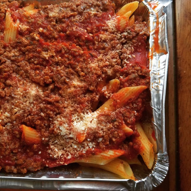 pasta covered in sauce in foil pan