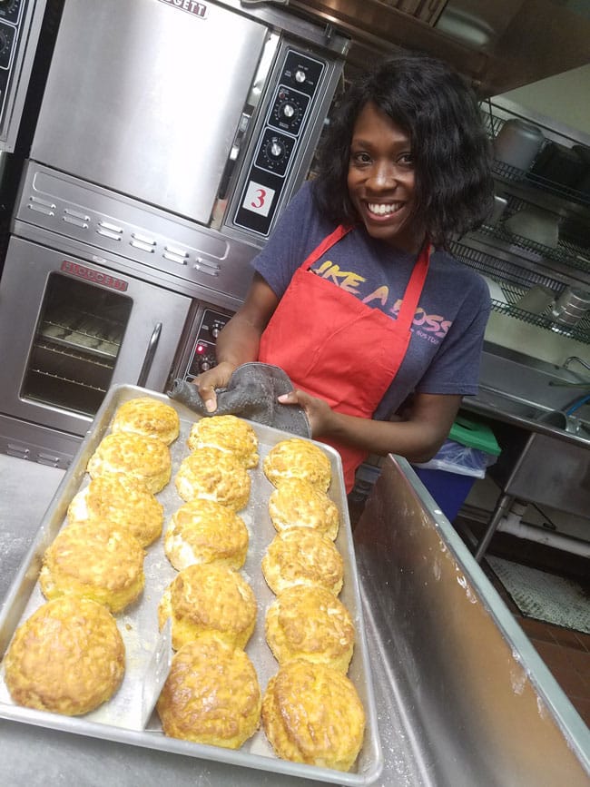 author holding up pan of baked biscuits