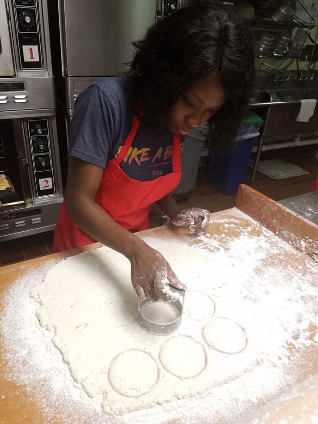 author using biscuit cutter to cut put biscuits