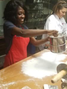 author putting flour on wooden table