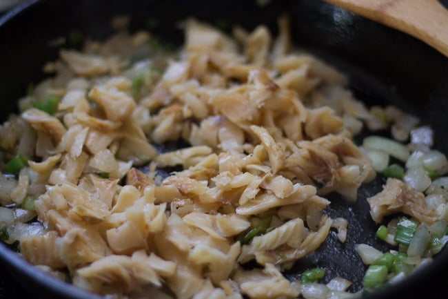 saltfish added to skillet with ingredients