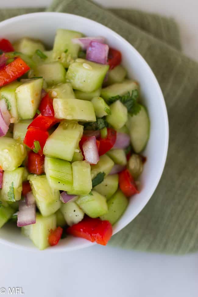 sweet chili thai cucumber salad and red peppers in white bowl