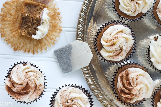 chai tea cupcakes on platter with tea bag in middle and half eaten cupcake on side