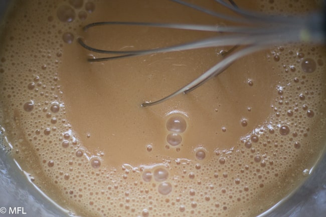 wet ingredients in bowl with whisk in it