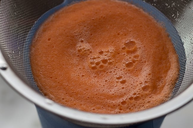 carrots in strainer. This Jamaican Style Carrot Juice Recipe is authentic and delicious! Perfect recipe for a hot summer day. #jamaicanrecipe #carrotjuice #condensed milk #juicerecipes