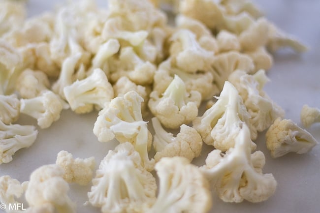 cauliflower broken into pieces on white background