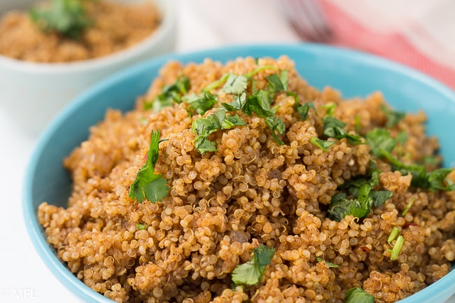 quinoa in blue bowl topped with fresh chopped cilantro