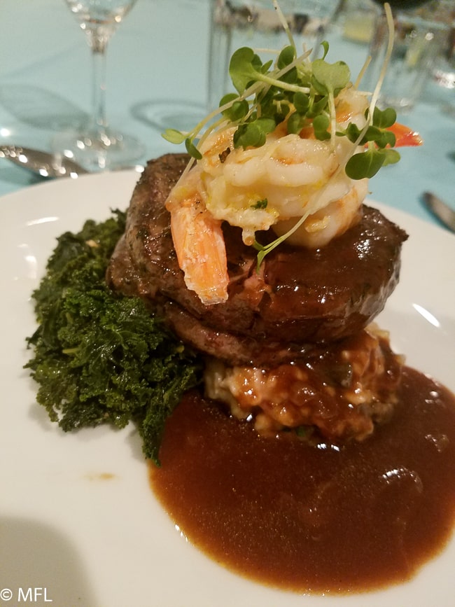 filet mignon with shrimp on top over kale and risotto