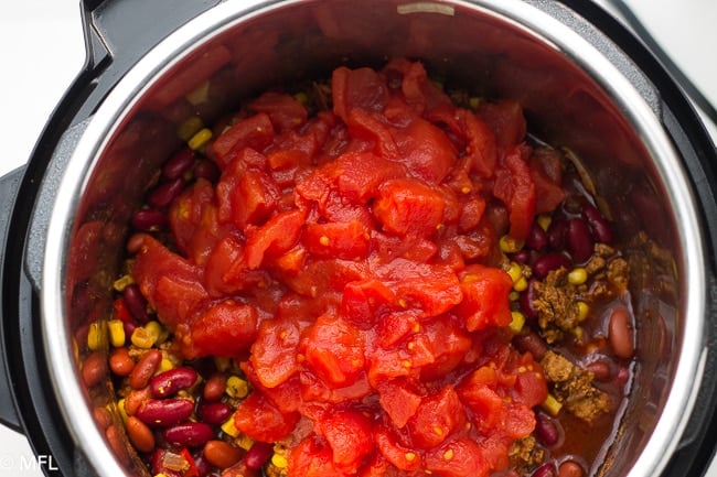 pressure cooker turkey chili in the instant pot with tomatoes on top