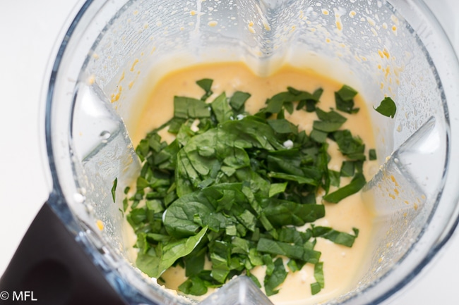 blended ingredients with spinach on top