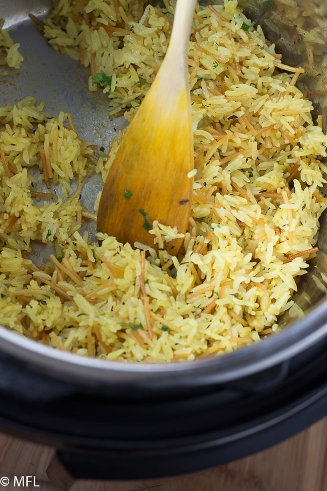 rice in instant pot insert with wooden spoon in it