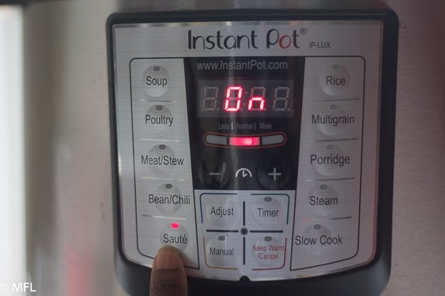 instant pot display with finger pressing saute and display says on