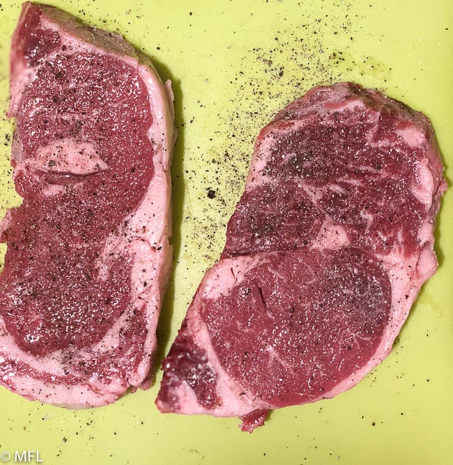 steak seasoned with salt and pepper on mat