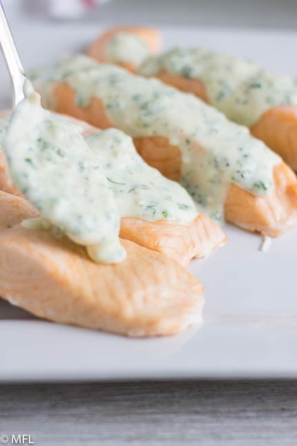 salmon being covered with sauce