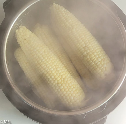 steam coming out of the instant pot with corn