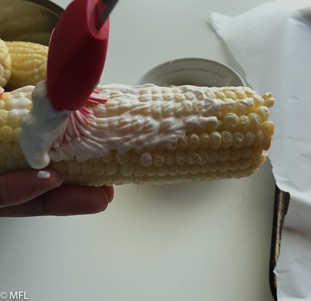 cream being spread on corn