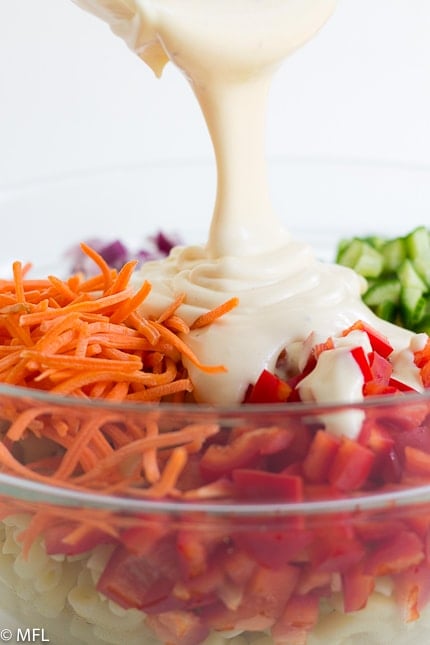 sauce being poured on vegetables