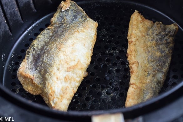 fish filets in air fryer basket after cooking