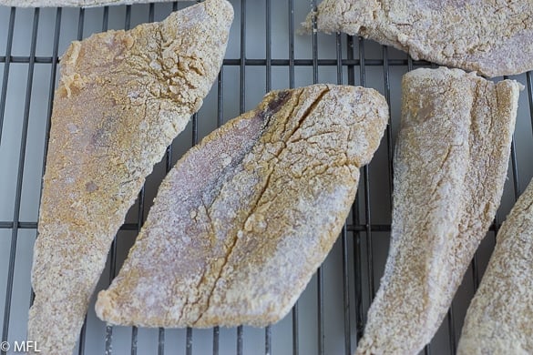 dredged air fryer fish on baking tray 