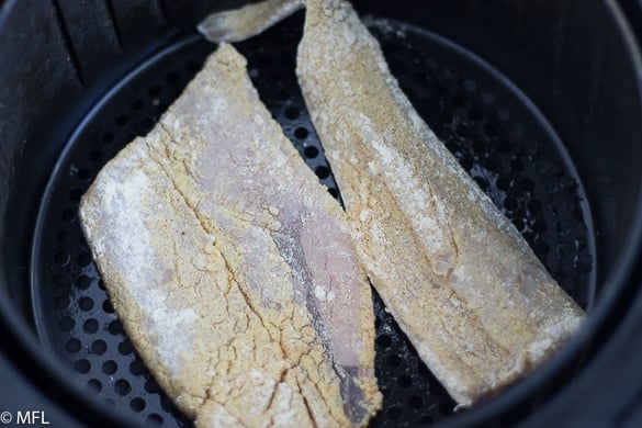 fish filets in air fryer basket before cooking