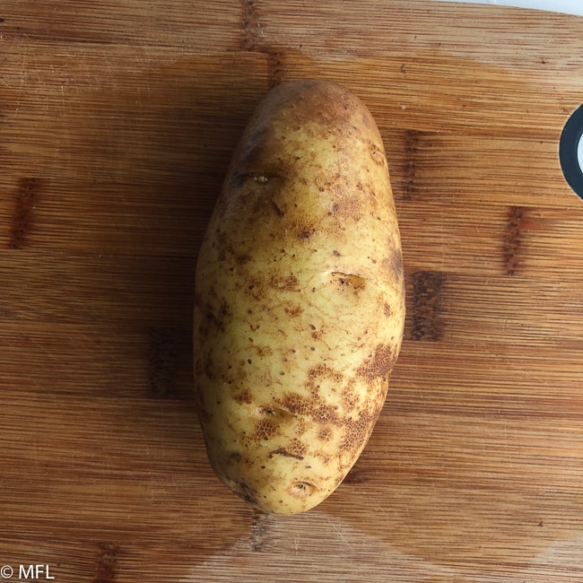 whole potato on cutting board
