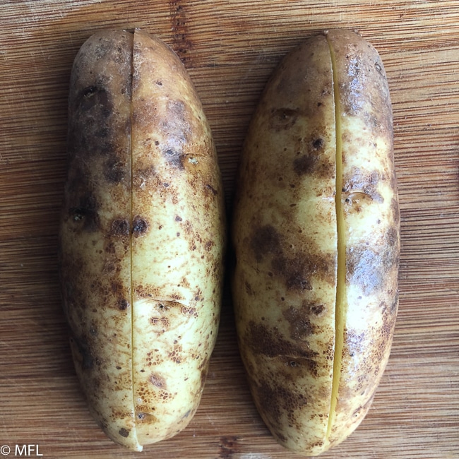potato cut in half on cutting board