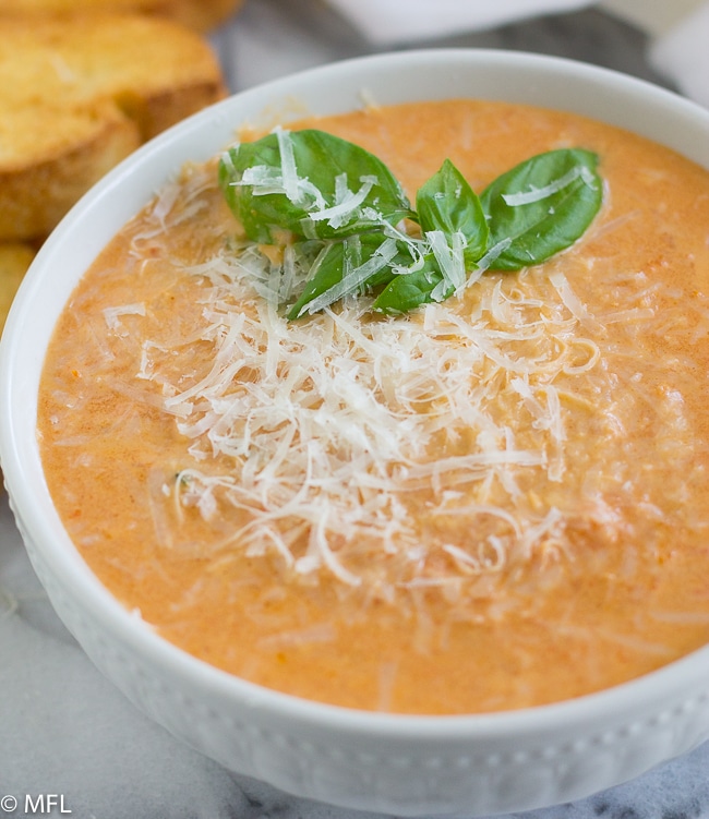 tomato soup in bowl with basil on top