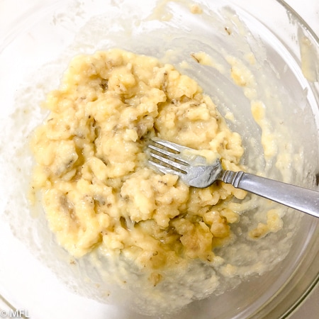 mashed banana in bowl with fork