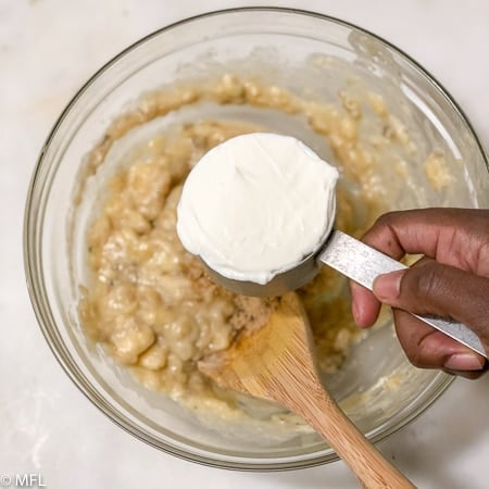 sour cream in cup over bowl