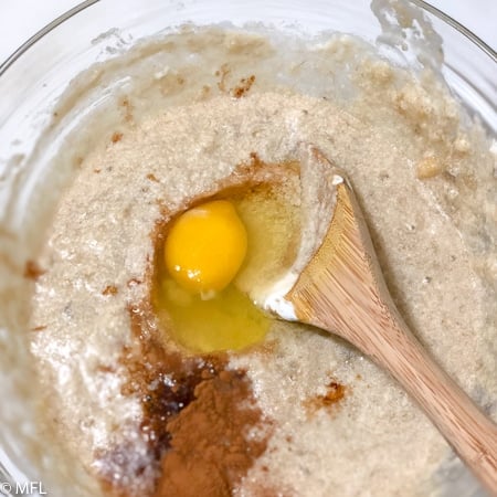 egg in batter with wooden spoon