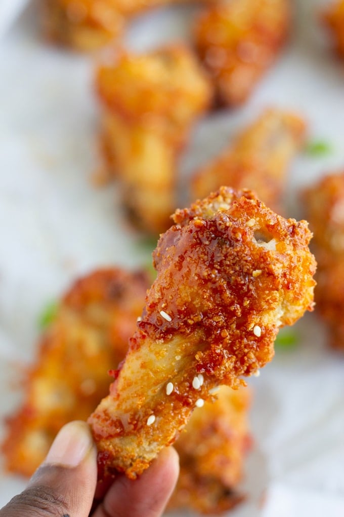 photo of air fryer chicken wing being held in the air