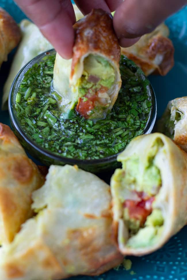 air fryer avocado egg roll being dipped in sauce