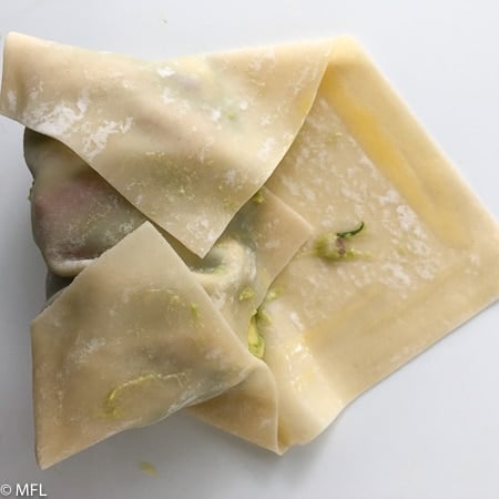 egg roll wrapper rolled halfway with avocado filling inside. These Copycat Cheesecake Factory Avocado Rolls are made in the Air Fryer and have half the calories and fat than the restaurant version. They are healthy but have the same great taste and crunch. #airfried #airfryerrecipe #copycatrecipe #avocadorecipes #dippingsauce
