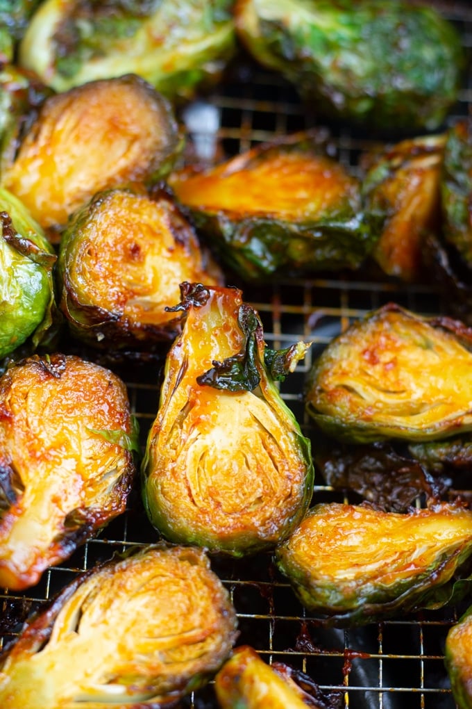 These Sweet and Spicy Air Fryer Brussel Sprouts come out perfect when cooked in your Air Fryer. Toss them in a Korean style sauce for the perfect vegetable side dish. #airfryerrecipe #airfryer#airfryervegetables air fryer brussels sprouts roasted in the air fryer basket