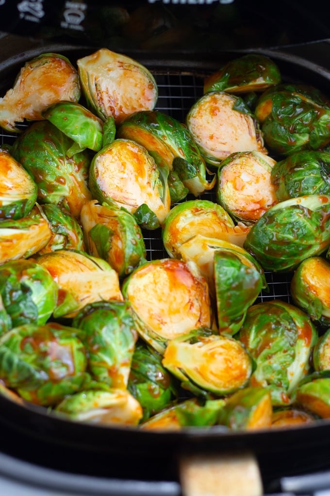 brussels sprouts covered in sauce in air fryer basket