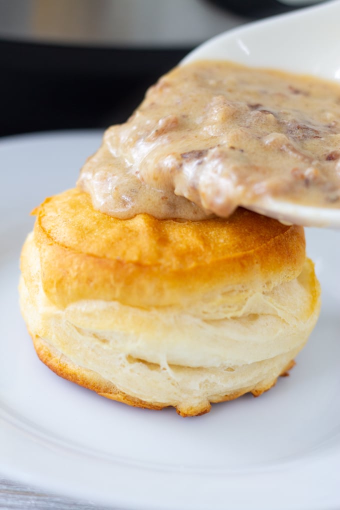 gravy being poured over biscuit