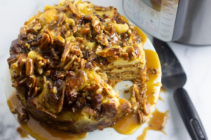 bread pudding on white plate in front of pressure cooker machine