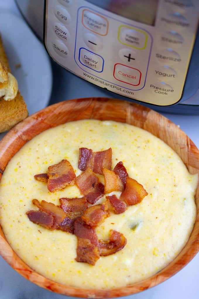 instant pot grits i en bolle toppet med baconstykker