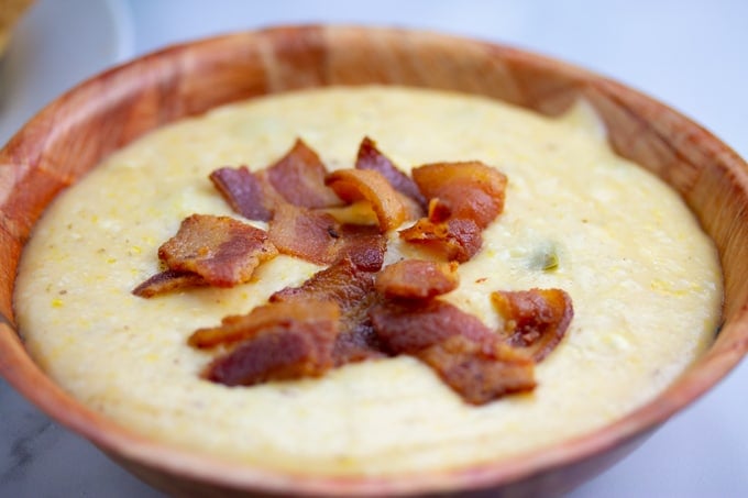 grits in bowl covered with cooked bacon