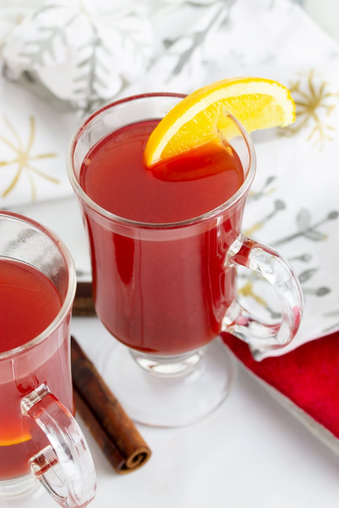 hot holiday punch in a glass with lemon sliced on side