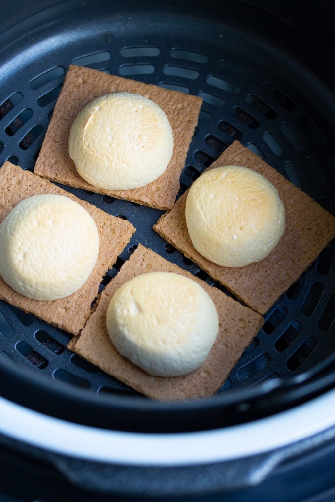 You won’t need a campfire to make these s’mores, all you need is an Air Fryer. Delicious roasted marshmallows roasted right in the Air Fryer in less than 10 minutes. It’s the perfect easy dessert. #smallbatchdessert #airfryer #airfryerrecipes #airfryerrecipesfordessert #dessertrecipes roasted marshmallows on graham cracker in air fryer