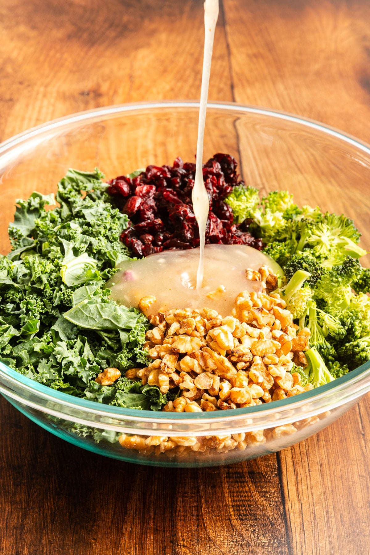 salad dressing being poured over salad