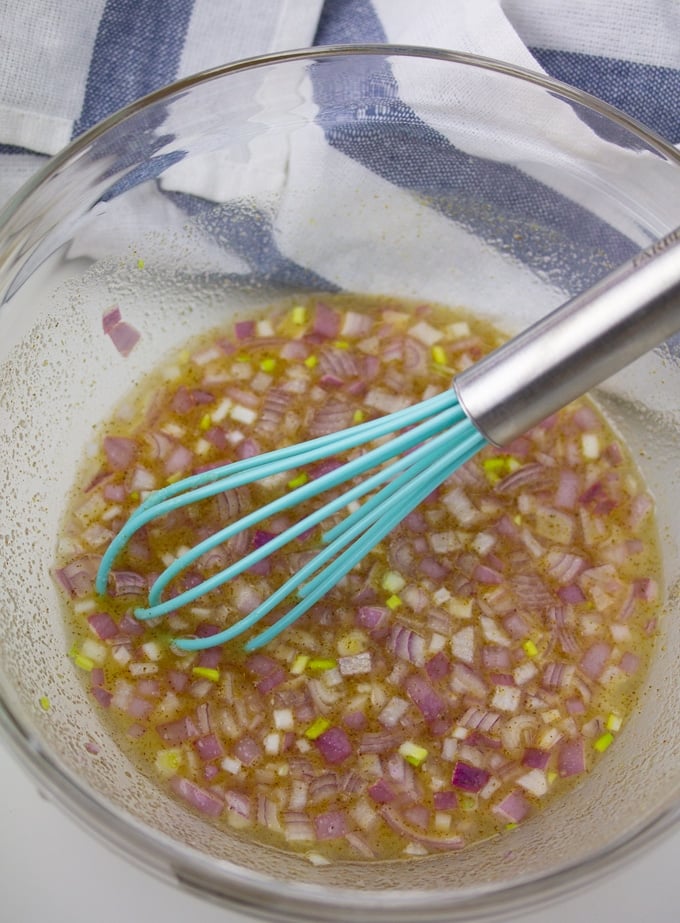 salad dressing in glass bowl with whisk in it