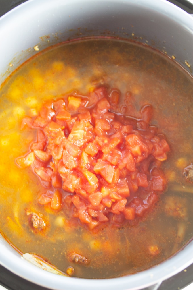 chicken broth with tomatoes on top of pressure cooker moroccan spiced soup